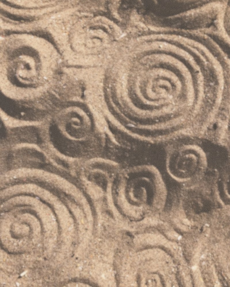 Ancient spirals carved into a weathered stone face.